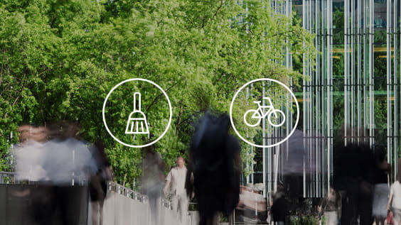 Personas con un árbol junto a un edificio de oficinas